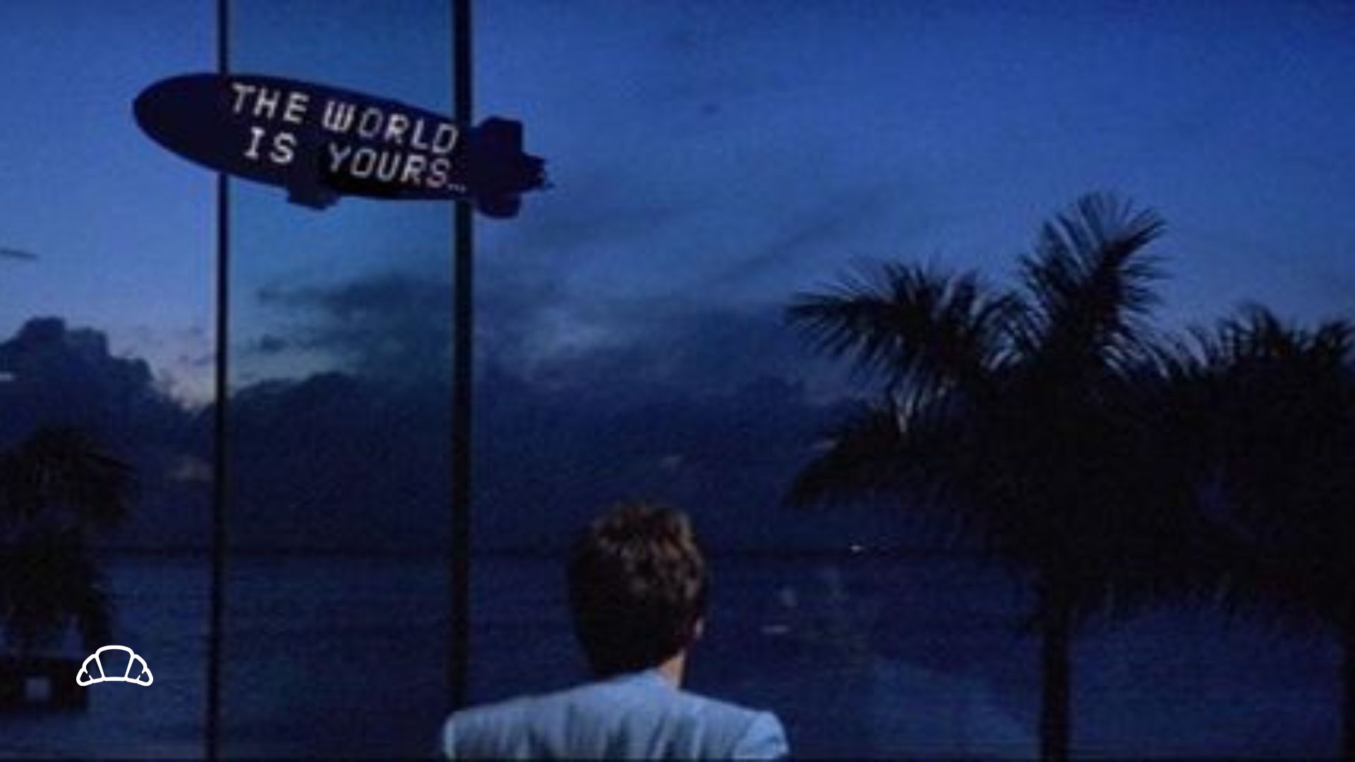 Immagine di Scarface con il cielo sullo sfondo e un cartellone a neon, simbolo della cultura pop degli anni '80.